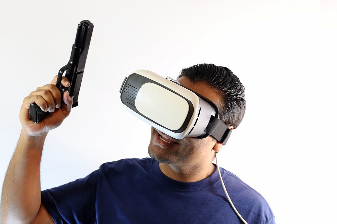 MIDSECTION OF MAN HOLDING CAMERA AGAINST WHITE BACKGROUND