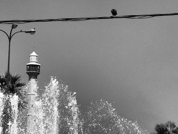 Low angle view of street light by building against sky