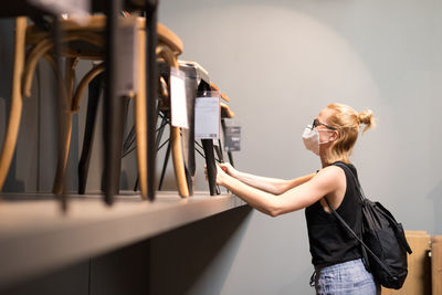 Woman wearing flu mask standing at store