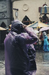 Rear view of woman with wet umbrella in rainy season