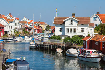 Boats moored in canal amidst buildings in city