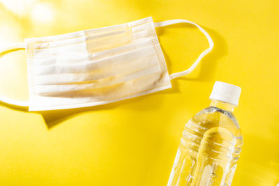 Close-up of glass bottle against yellow background