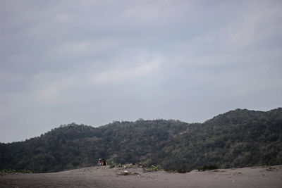 Scenic view of land and mountains against sky