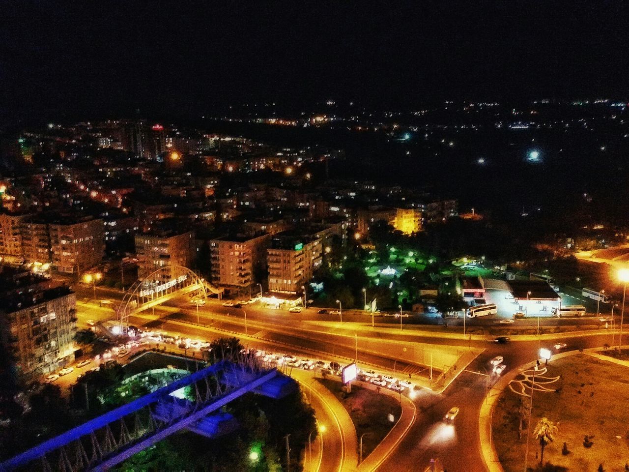 illuminated, night, city, high angle view, building exterior, architecture, cityscape, built structure, road, transportation, light trail, city life, street, aerial view, street light, traffic, sky, outdoors, car, no people