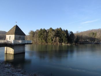 Scenic view of lake by building against blue sky