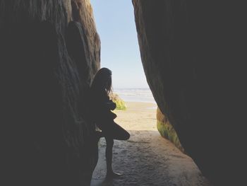 Woman standing amidst rock formations at beach