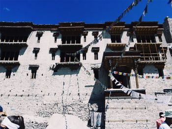 Low angle view of prayer flags on buildings during sunny day