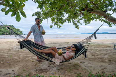 Rear view of man sitting at beach