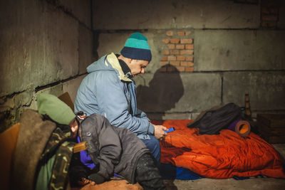 Ukrainian father with kids sits in bomb shelter and reads latest braking news about russian invaders