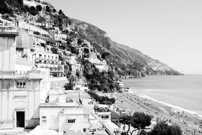 Scenic view of town by sea against clear sky