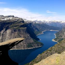 Scenic view of lake by mountains against sky