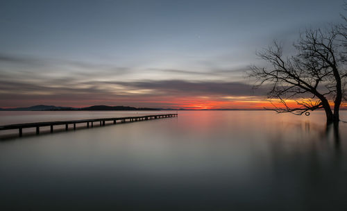 Scenic view of lake against sky at sunset