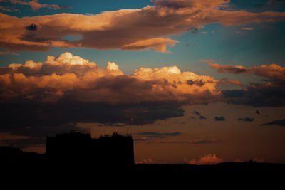 Silhouette city against sky during sunset