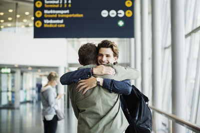 Happy businessman embracing male colleague at airport