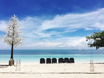 Chairs at beach against sky