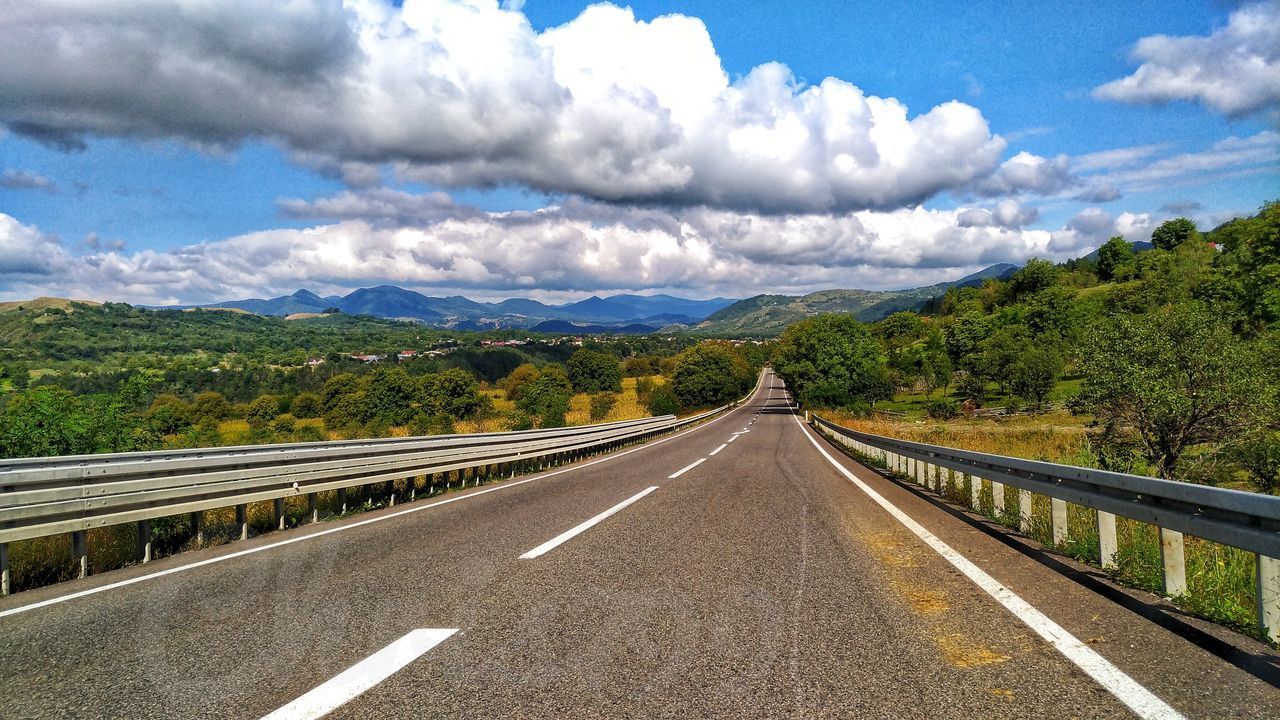 ROAD BY MOUNTAINS AGAINST SKY