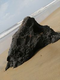 Close-up of rock on beach against sky