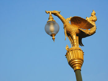 Low angle view of statue against clear blue sky