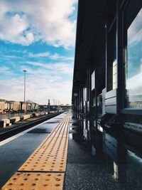 Railroad tracks in city against sky