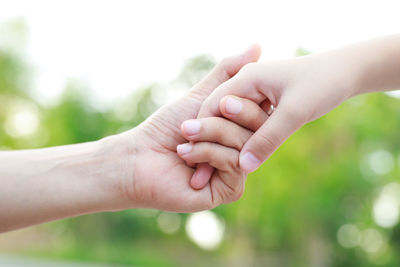 Cropped image of couple holding hands