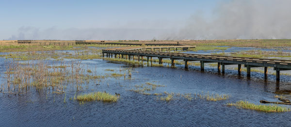 Panoramic view of a boardwalk in to a marshy wildlife refuge