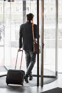 Businessman with luggage leaving hotel