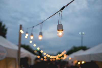 Illuminated lights in city against sky