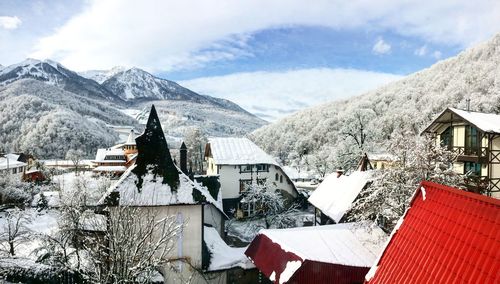 Houses on snowcapped mountain against sky