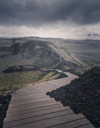 High angle view of footpath by mysterious landscape against sky in the mist.