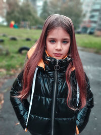 Portrait of girl wearing leather jacket standing outdoors