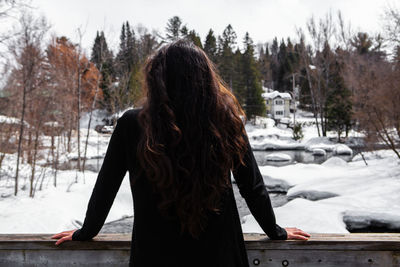 Rear view of woman standing in snow