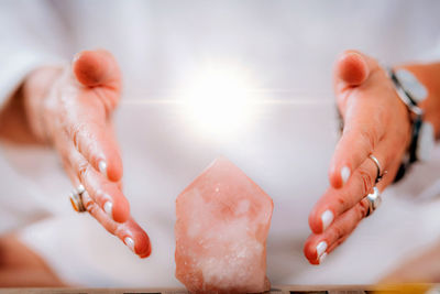 Self-awareness meditation concept. emotionally aware person holding hands around energized crystal