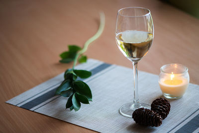 Pine cones and candle with wine on fabric