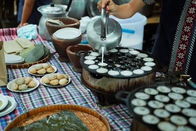 Midsection of woman preparing food on table at market stall