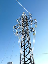 Low angle view of ice covered electricity pylon against clear sky
