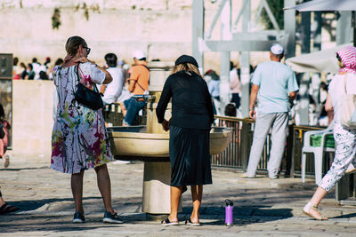 Rear view of people walking on street