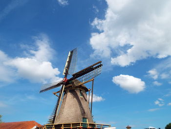 Low angle view of wind mill against blue sky. 