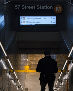 Rear view of man standing on escalator