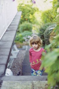 Full length of cute girl standing against plants