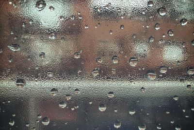 Full frame shot of raindrops on glass window