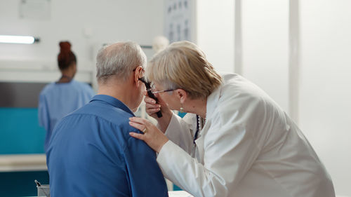 Side view of doctor examining patient in laboratory