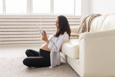 Woman sitting on sofa at home