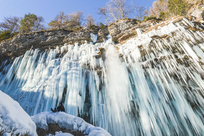 Low angle view of cliff during winter