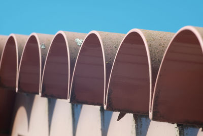 Low angle view of rooftop against clear blue sky