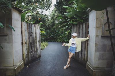 Full length of woman standing by plants