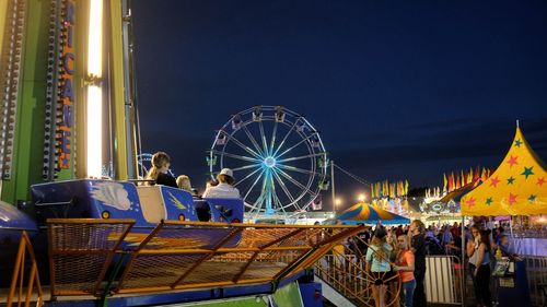 People enjoying rides at gage county agricultural against sky