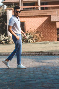 Portrait of man walking on footpath