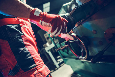 Midsection of man repairing motorcycle