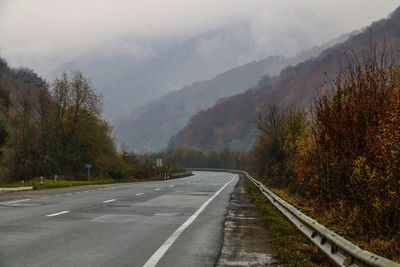 Road by mountains against sky