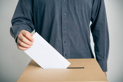 Close-up of man wearing paper against white background
